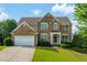 Charming two-story brick home with a lush green lawn and beautiful landscaping at 773 Van Briggle Path, Sugar Hill, GA 30518