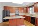 Well-equipped kitchen with dark wood cabinetry, island, and stainless steel appliances at 773 Van Briggle Path, Sugar Hill, GA 30518