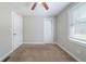 Neutral bedroom featuring two closets, tan carpet, ceiling fan and a bright window at 10150 Puckett St, Covington, GA 30014