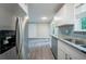 Modern kitchen with stainless steel refrigerator, granite countertops, and gray backsplash at 10150 Puckett St, Covington, GA 30014