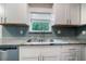 Close-up of the kitchen sink area, featuring granite countertops, a stylish faucet, and a subway tile backsplash at 10150 Puckett St, Covington, GA 30014