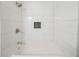 Bright white tiled shower with recessed storage and modern fixtures at 10150 Puckett St, Covington, GA 30014