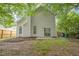 Back of home with fenced yard, small patio, plantings, and some mature trees at 161 Stoneforest Dr, Woodstock, GA 30189