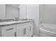 Bathroom with a stylish vanity, granite countertop, and a bathtub with white tile surround at 161 Stoneforest Dr, Woodstock, GA 30189