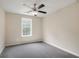 This carpeted bedroom features neutral walls, a ceiling fan, and a window providing natural light at 161 Stoneforest Dr, Woodstock, GA 30189