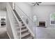 Spacious living room adjacent to the staircase with fireplace and arch window providing lots of natural light at 161 Stoneforest Dr, Woodstock, GA 30189
