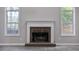 Cozy living room with a traditional brick fireplace, flanked by windows offering ample natural light at 161 Stoneforest Dr, Woodstock, GA 30189