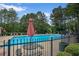 Community pool area with lounge chairs and umbrellas surrounded by mature trees at 161 Stoneforest Dr, Woodstock, GA 30189