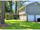 Features a spacious wooden deck, lush green lawn, and a convenient two-car garage, ideal for outdoor living and parking at 9218 River Chase Way, Jonesboro, GA 30238