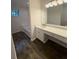 Bright bathroom with a large mirror, vanity with white cabinets, and wood-look flooring at 101 Dancing Fox Rd, Decatur, GA 30032