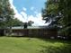 Brick home exterior with green metal roof and back porch overlooking a large lawn at 1253 Gatewood Drive Dr, Lawrenceville, GA 30043