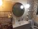 Well lit bathroom includes floral wallpaper, toilet, vanity sink and round mirror at 1253 Gatewood Drive Dr, Lawrenceville, GA 30043