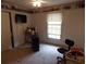 Bedroom featuring neutral carpet, window, TV, and shelves displaying collectible cars at 1253 Gatewood Drive Dr, Lawrenceville, GA 30043