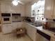 Bright kitchen features white cabinetry, tiled countertops, and classic black-and-white flooring at 1253 Gatewood Drive Dr, Lawrenceville, GA 30043