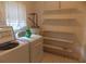 Functional laundry room with washer, dryer, water heater, shelving and natural light at 1253 Gatewood Drive Dr, Lawrenceville, GA 30043
