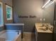 Bright bathroom featuring double sinks, a large mirror, and a bathtub beneath a window at 169 Rachel Blvd, Temple, GA 30179