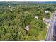 Aerial view of a wooded lot with mature trees, a house, a highway, and surrounding neighborhood at 4443 Flat Shoals Pkwy, Decatur, GA 30034
