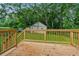 Back deck with wood railing overlooks grassy lawn with mature shade trees in the backyard at 4443 Flat Shoals Pkwy, Decatur, GA 30034