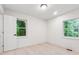 Bright bedroom with white walls, two windows, light wood floors, and modern lighting at 4443 Flat Shoals Pkwy, Decatur, GA 30034