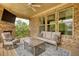 Cozy outdoor back porch area with an outdoor couch, chair, fireplace and TV at 4895 Sterling Close, Buford, GA 30518