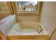 Close up view of a soaking tub with bronze hardware in a bright bathroom at 4895 Sterling Close, Buford, GA 30518