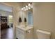 Well-lit bathroom with a white single sink vanity and framed mirror adjacent to an open doorway at 4895 Sterling Close, Buford, GA 30518