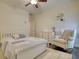 Comfortable bedroom with hardwood floors, neutral walls, ceiling fan, a cozy chair, and soft carpet at 4895 Sterling Close, Buford, GA 30518