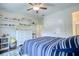 Comfortable bedroom with shelving for decor, neutral walls, ceiling fan, and a soft carpet at 4895 Sterling Close, Buford, GA 30518
