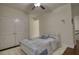 Well-lit bedroom featuring a cozy bed, a soft rug, and a ceiling fan for added comfort at 4895 Sterling Close, Buford, GA 30518