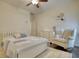 Bedroom features a white framed bed and chair, a dresser, and a ceiling fan at 4895 Sterling Close, Buford, GA 30518