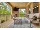 Inviting covered patio with a brick fireplace, TV, cozy furniture, and pleasant view for outdoor living at 4895 Sterling Close, Buford, GA 30518