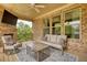 Stylish covered patio with brick fireplace, TV, comfortable seating, and serene outdoor setting at 4895 Sterling Close, Buford, GA 30518