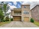 Beautiful brick home featuring a two-car garage and a balcony overlooking the lush green lawn at 4895 Sterling Close, Buford, GA 30518