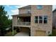 Back of the two-story brick home with a second-story porch and a lower-level garage for two cars at 4895 Sterling Close, Buford, GA 30518
