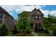 Two-story home showcasing stone and siding exterior, manicured lawn, and mature trees at 4895 Sterling Close, Buford, GA 30518