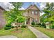 Charming two-story brick home featuring a cozy front porch and professionally landscaped yard at 4895 Sterling Close, Buford, GA 30518
