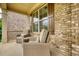 Inviting front porch featuring comfortable wicker chairs with cushions and brown shutters on a brick home at 4895 Sterling Close, Buford, GA 30518