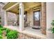 Charming front porch with brick accents, a cozy seating area, and a welcoming entrance door at 4895 Sterling Close, Buford, GA 30518