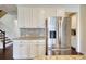Kitchen area with white cabinets, stainless refrigerator, and access to stairs at 4895 Sterling Close, Buford, GA 30518