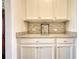 Kitchen area featuring cabinets, countertops, backsplash, and stainless coffee maker at 4895 Sterling Close, Buford, GA 30518