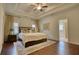Luxurious main bedroom featuring a tray ceiling, hardwood floors, and elegant decor for a comfortable retreat at 4895 Sterling Close, Buford, GA 30518