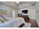 Spacious main bedroom with hardwood floors, tray ceiling and mounted TV at 4895 Sterling Close, Buford, GA 30518