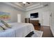 Bright main bedroom showcasing hardwood floors, a ceiling fan, and a large television for ultimate relaxation at 4895 Sterling Close, Buford, GA 30518