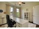 Comfortable home office with a large white desk, modern furnishings, and natural light from two windows at 4895 Sterling Close, Buford, GA 30518