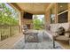 Comfortable covered patio with neutral furniture, a brick fireplace, and a view of the backyard at 4895 Sterling Close, Buford, GA 30518