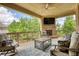 Relaxing covered patio with outdoor furniture, brick fireplace, and ceiling fan, ideal for entertaining at 4895 Sterling Close, Buford, GA 30518