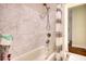 Shower features a tub with marble-look tile surround and a clear and gray striped shower curtain at 4895 Sterling Close, Buford, GA 30518