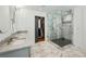 Bright bathroom featuring double vanity with marble countertops, frameless glass shower, and spacious walk-in closet at 6175 Weatherly Dr, Sandy Springs, GA 30328