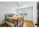 Cozy bedroom featuring hardwood floors, iron bed frame, a ceiling fan, and plantation shutters at 6175 Weatherly Dr, Sandy Springs, GA 30328