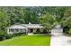Charming home with a well-manicured lawn, mature trees, and a welcoming facade, complete with a three car garage at 6175 Weatherly Dr, Sandy Springs, GA 30328